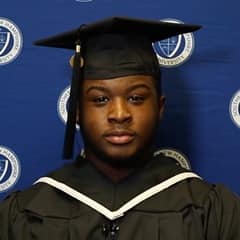 Hassan Seales in a graduation cap and gown, celebrating his 2023 liberal arts associate degree from SNHU
