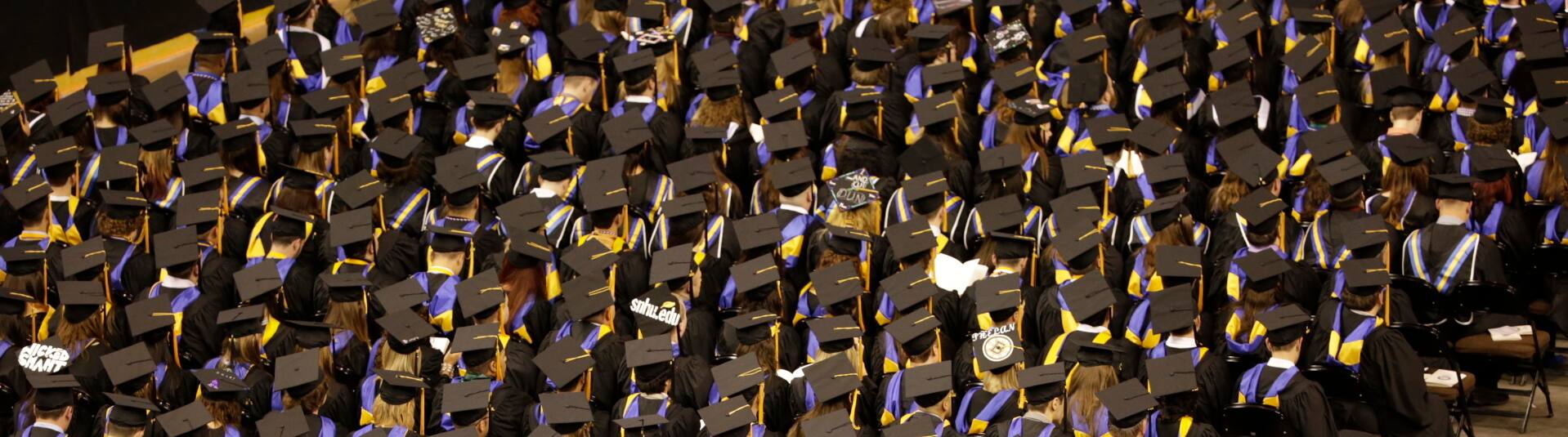 Image of students with caps and gowns at commencement 