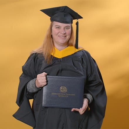 AnnMarie Kulis, an SNHU graduate with a bachelor's in general studies and master's in healthcare administration, wearing a graduation cap and gown.