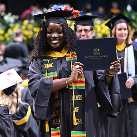 SNHU graduate showing off her diploma during the 2024 SNHU Commencement Weekend