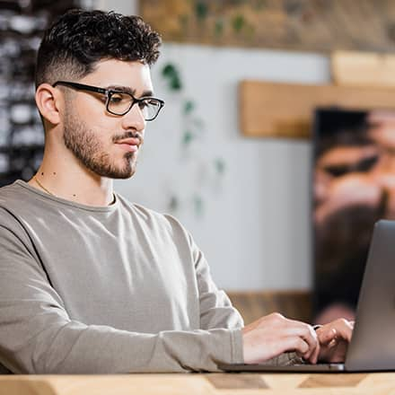 Naeem Jaraysi using a laptop to earn his marketing degree at SNHU