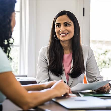 A woman speaking with another woman about her helping profession role