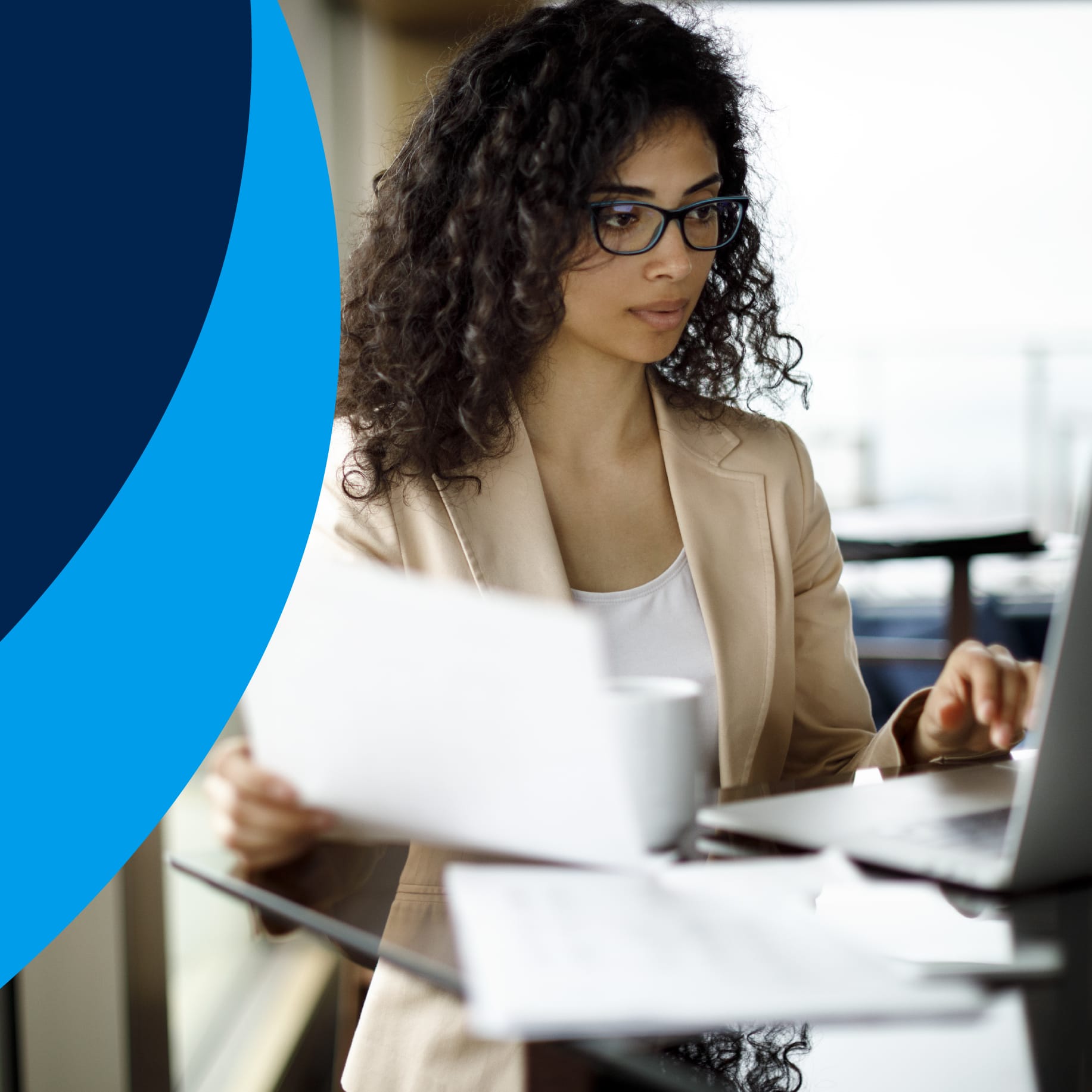 A woman standing at her desk working on her laptop next to a dollar sign on a blue background.