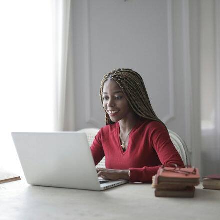 A student using a laptop to research how to write an MFA thesis