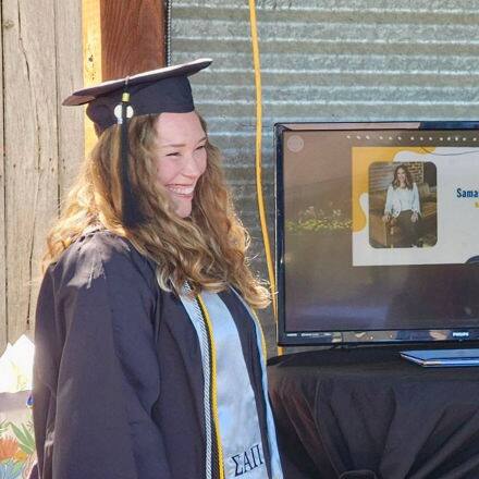 Samantha Sherwood '24, an SNHU graduate, in a cap and gown watching her name be called at SNHU's virtual Commencement.