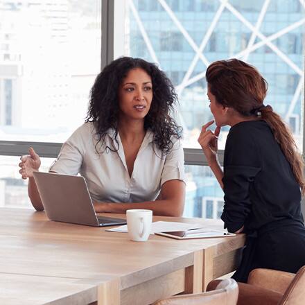 Two human resources professionals in discussion at a meeting.