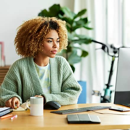 A professional upskilling at her desk, using a computer.