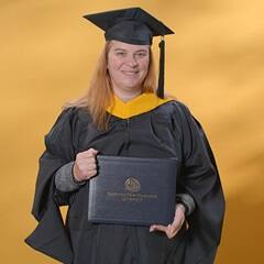 AnnMarie Kulis, an SNHU graduate with a bachelor's in general studies and master's in healthcare administration, wearing a graduation cap and gown