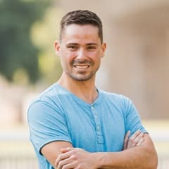 Blake Venable, a 2022 SNHU graduate who earned his bachelor's in accounting, standing with his arms crossed in a blue shirt.