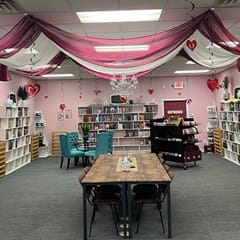 The inside of the bookstore Pages and Grapes with bookshelves and tables.