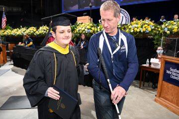 Ryan Menter ‘22, who lost his vision as an infant due to a pediatric brain tumor, after accepting his diploma.
