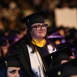 Demetria Garduno in a graduation cap and gown, standing at the SNHU Spring 2024 Commencement