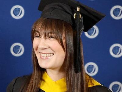 Emily Bevens, who earned her master's in psychology with a concentration in forensic psychology from SNHU in 2023, wearing her graduation cap and gown.