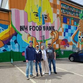 Four volunteers standing outside of the New Hampshire Food Bank during SNHU's Global Days of Service