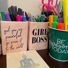 Three pencil holders with motivational messages, containing pens, markers and highlighters.