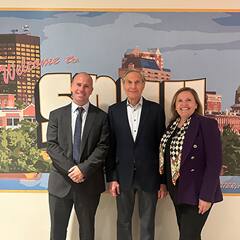 Diego Nocetti, Dean of SNHU’s School of Business, Howard Brodsky and President Lisa Marsh Ryerson standing in front of a Welcome to SNHU mural.