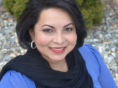 Katrina Jagroop-Gomes, who earned her MBA from SNHU in 2015, wearing a blue blouse and black scarf.