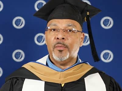 Jeffrey Harris, who earned his online MBA from SNHU in 2023, wearing his graduation cap and gown.