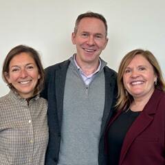 Jim Chilton '98MBA (middle), standing with Winnie Lerner (left), Officer and Board Chair of the Board of Trustees, and Lisa Marsh Ryerson (right), University President and Chief Executive Officer.