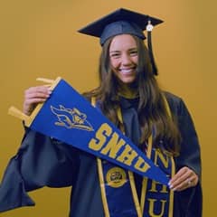 Kellsie Goodhart-Jones, a 2025 SNHU graduate who earned her online MBA with a concentration in Engineering Management holding an SNHU flag.