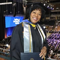 Marilynn Hymon-Williams dressed in a graduation cap and gown after earning a bachelor's in business administration from SNHU in 2022