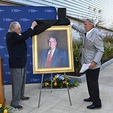 Artist Richard Whitney, left, unveiling a portrait of Mark A. Ouellette, right.