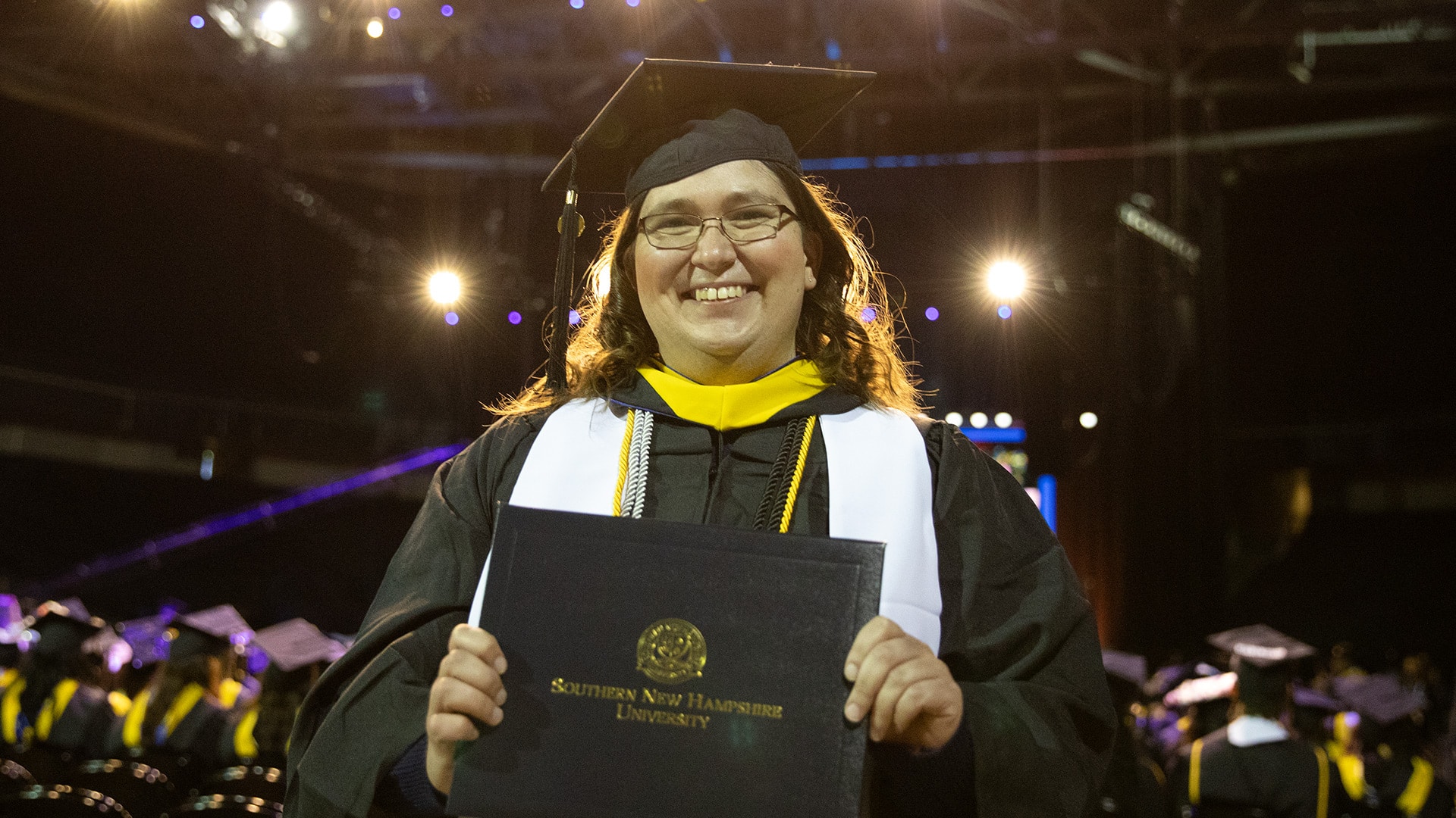 Karie Lamb, holding her online business degree diploma at SNHU's 2023 commencement ceremony.