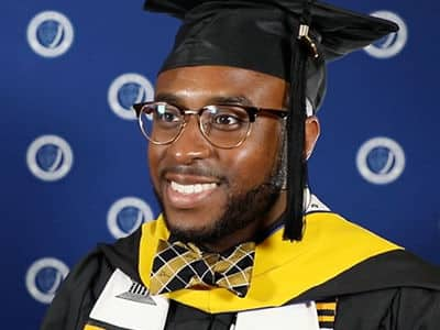 Rakia Green, who earned his master's in healthcare administration from SNNU in 2023, wearing his graduation cap and gown.