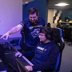 Two SNHU students working together in the Esports arena. 