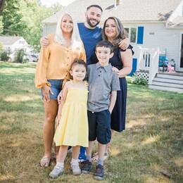 Stephen Goulakos, center, standing between his wife, left, and his mother, right, with his two children in front of them.