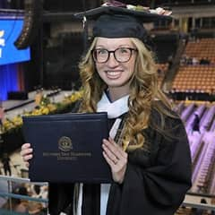 Victoria Meuse dressed in a graduation cap and gown after earning a bachelor's in psychology at SNHU in 2022