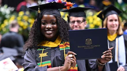 SNHU graduate showing off her diploma during the 2024 SNHU Commencement Weekend