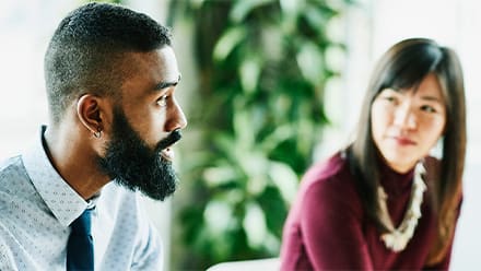 A person practicing empathy in the workplace as she listens to her colleague.