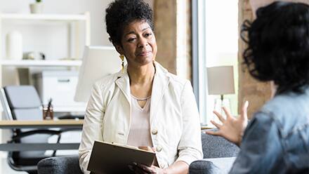 A psychiatrist speaking to a patient in their office