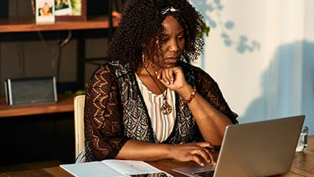 A woman working on her online graduate certificate courses from her laptop