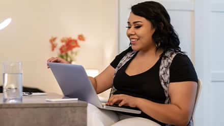 An adult learner discovering how online courses work, sitting at a desk with a laptop.