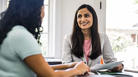 A woman speaking with another woman about her helping profession role