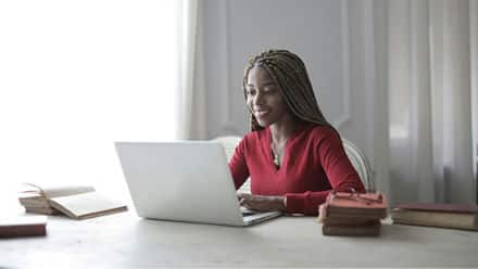 A student using a laptop to research how to write an MFA thesis