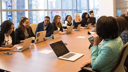 A group of public relation specialists discussing what they do while sitting at a conference table