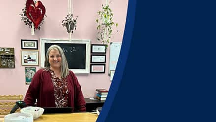 Heather Wejroch '23, an SNHU bachelor's in business administration graduate, standing behind the counter in Pages and Grapes.