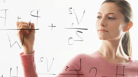 A woman with a math degree working on equations