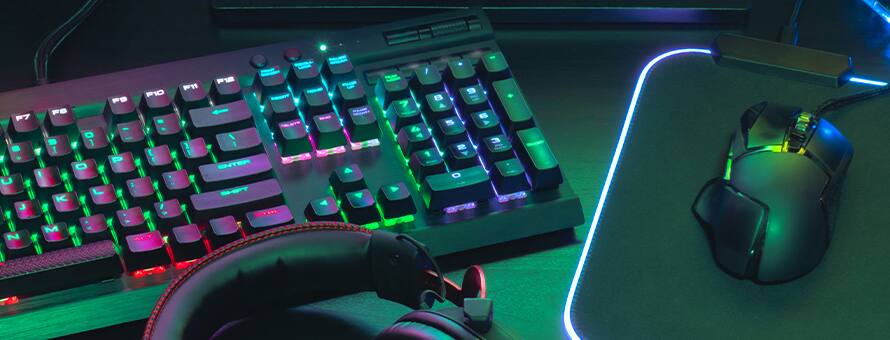 A LED keyboard, mouse and headset on a game developer's desk