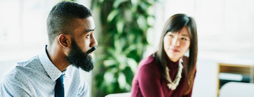 A person practicing empathy in the workplace as she listens to her colleague.