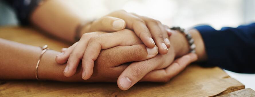 A close up shot of two hands holding onto one another