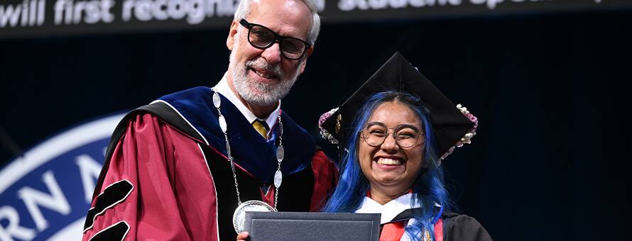 President Paul LeBlanc giving the 2024 Campus Undergraduate, Graduate and Doctoral Programs student speaker, Kayleigh An Philip, their diploma.