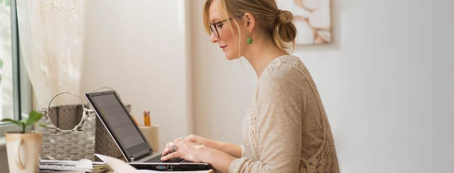 A student at a desk, typing on a computer