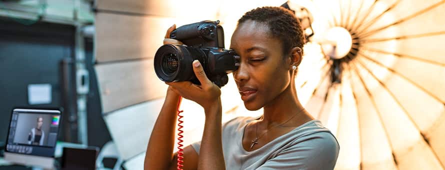 A woman using a camera while working in a photography studio