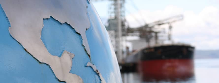 A globe statue by a seaport.