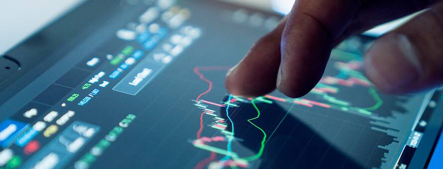 A hand hovering over a screen with a graph and different types of data on it showcasing what business analytics is