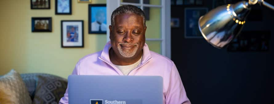 Corey Dantzler, an SNHU graduate working on his masters degree from his home desk.